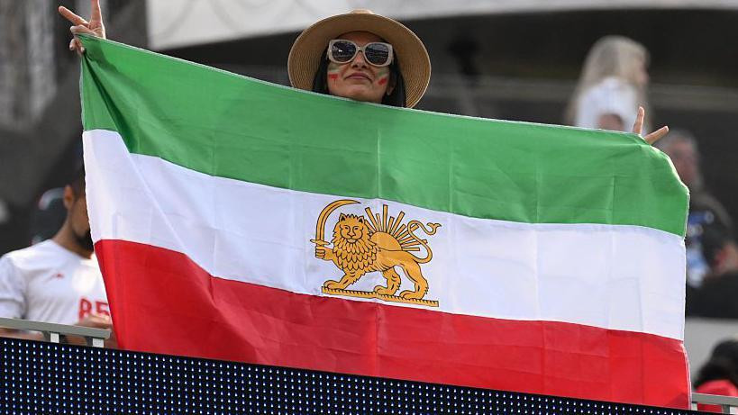 FIFA je zastave iz perioda pre revolucije zabranila na stadionima, ali neke su se provukle na stadion za utakmicu protiv Novog Zelanda