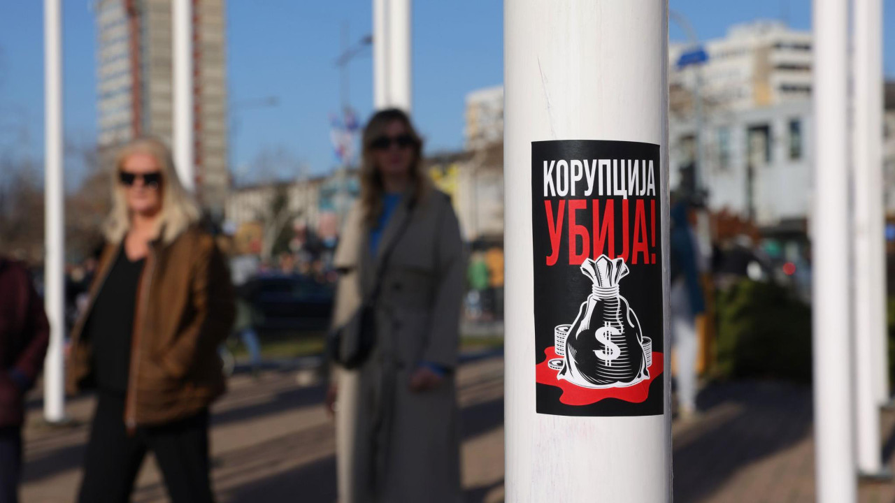 Na banderi je poster na kojem piše - korupcija ubija a ispod je nacrtan džak sa simbolom američkog dolara