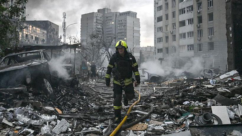 A rescuer walks through the wreckage of a building in Kyiv.