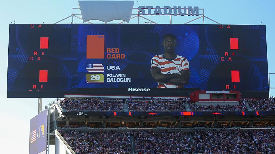 pogled na veliki ekran na stadionu, na njemu je lik fudbalera Balogana