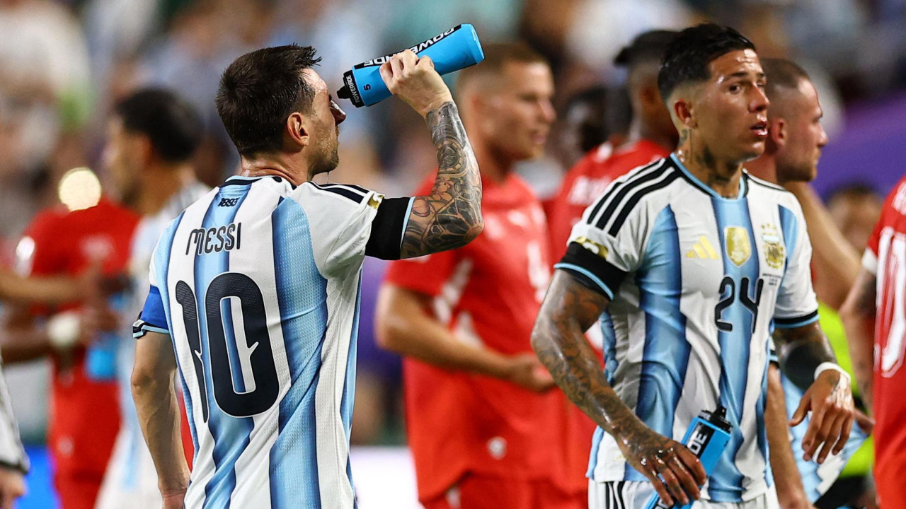 
                    Kapiten Argentine Lionel Mesi, okrenut leđima kameri, poliva se vodom po licu tokom pauze za osveženje u drugom poluvremenu utakmice protiv Švajcarskom u četvrtfinalu Svetskog prvenstva u fudbalu 2026. na stadionu Kanzas Sitija u SAD. Njegov saigrač Enco Fernandez je sa njegove desne strane, a neko