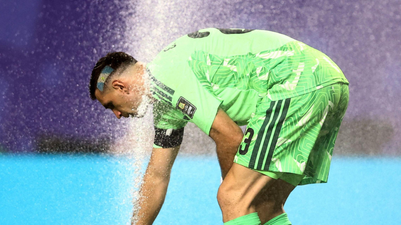 Argentinski golman Emilijano Martinez koristi prskalicu na terenu stadiona u Kanzas Sitija da se ohladi tokom pobede nad Švajcarskom od 3:1 u četvrtfinalu 