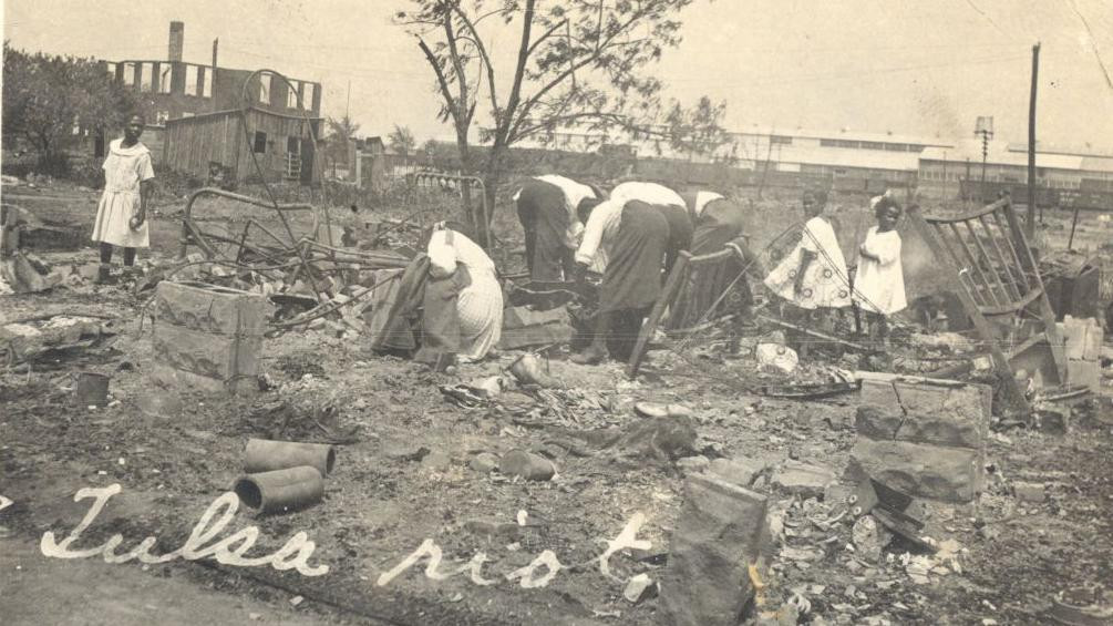 crno-bela fotografija na kojoj petoro odraslih Afroamerikanaca pretražuje ostatke potpuno uništene zgrade 