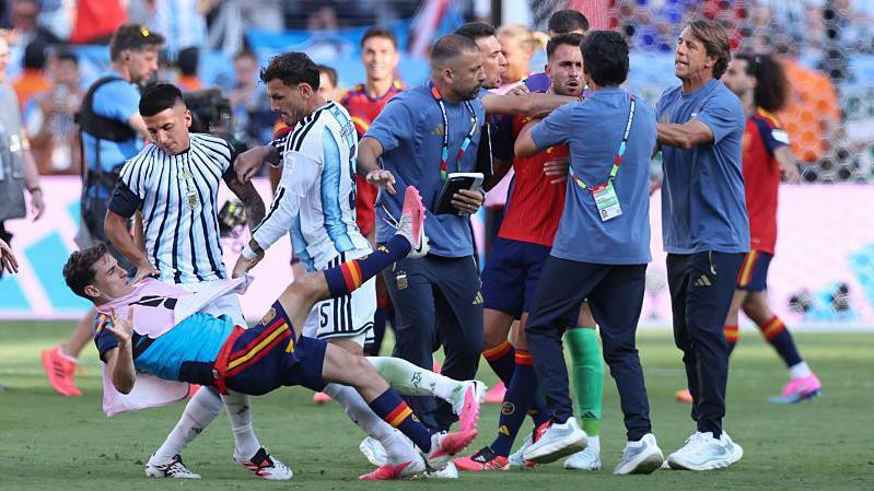 Tijago Almada i Leandro Paredes bacaju Španca Gavija na teren, dok pomoćni trener Roberto Ajala drži Erika Garsiju za grlo 