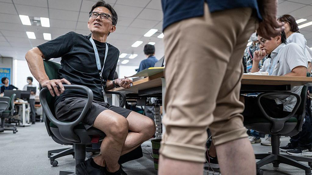 Japanac u kancelariji, nosi bermude 