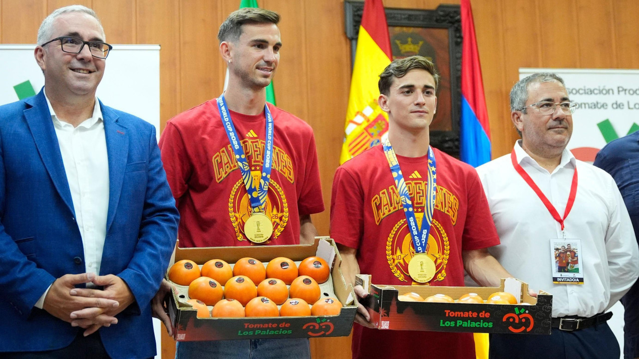 Četiri muškarca, jedan u plavom odelu, u sredini dvojica u dresu španske reprezentacije i medaljama oko vrata i na kraju stariji čovek u beloj košulji