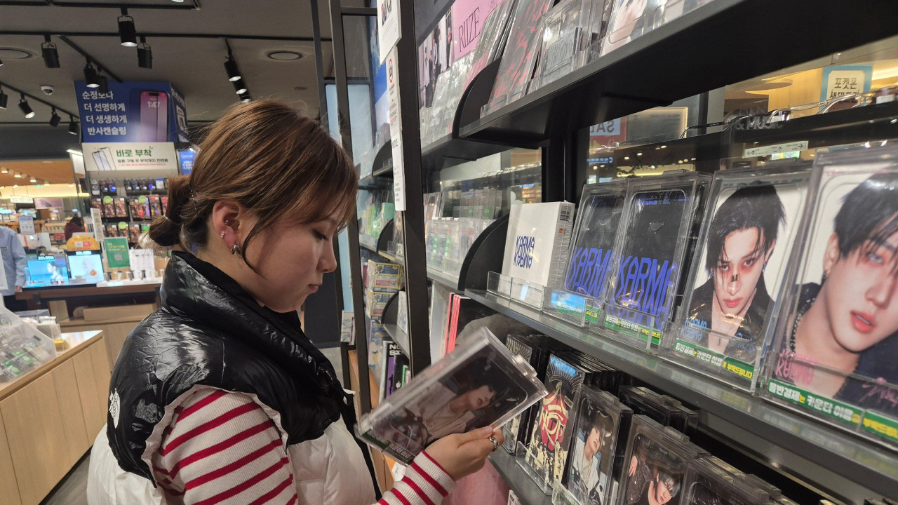 Gju-Ri razgleda kej-pop albume u muzičkoj prodavnici u Seulu
