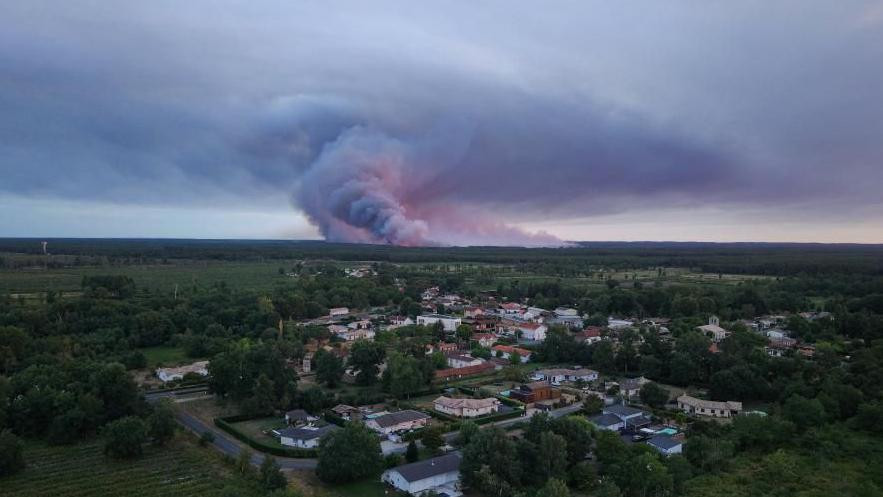 Fotografija prikazuje opštinu Sent-Elen u Francuskoj gde se vidi dim koji se diže u pozadini tokom šumskog požara u šumskom području u Saumosu 