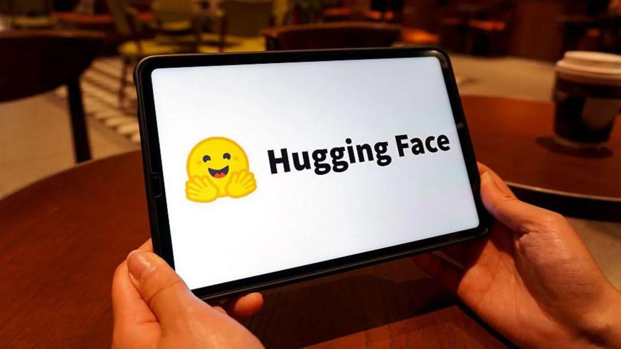 Na belom ekranu simbol nasmejanog lica žute boje pored kojeg je ispisano hugging face