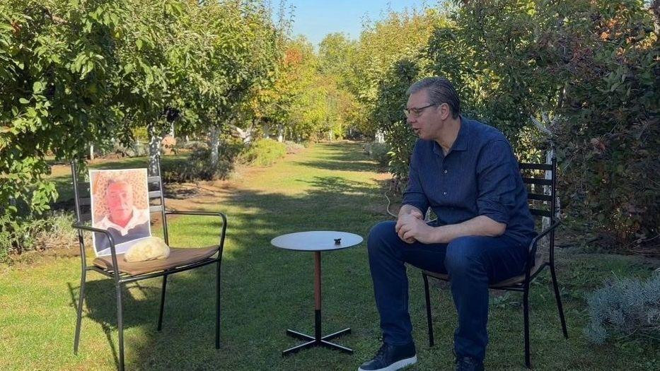 Aleksandar Vučić sedi na stolici u bašti 