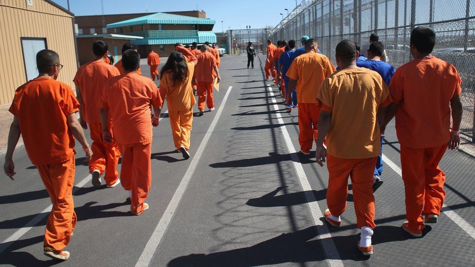 Prisoners walking by a perimeter fence in a jail in the United States