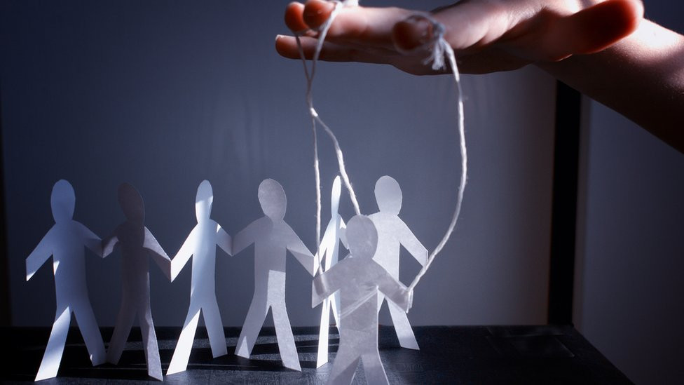 Image of human figures being moved by strings