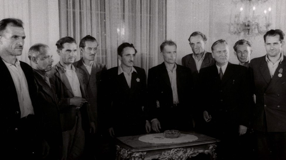 Grupa radnika okupljena oko Tita u prijemnoj prostoriji