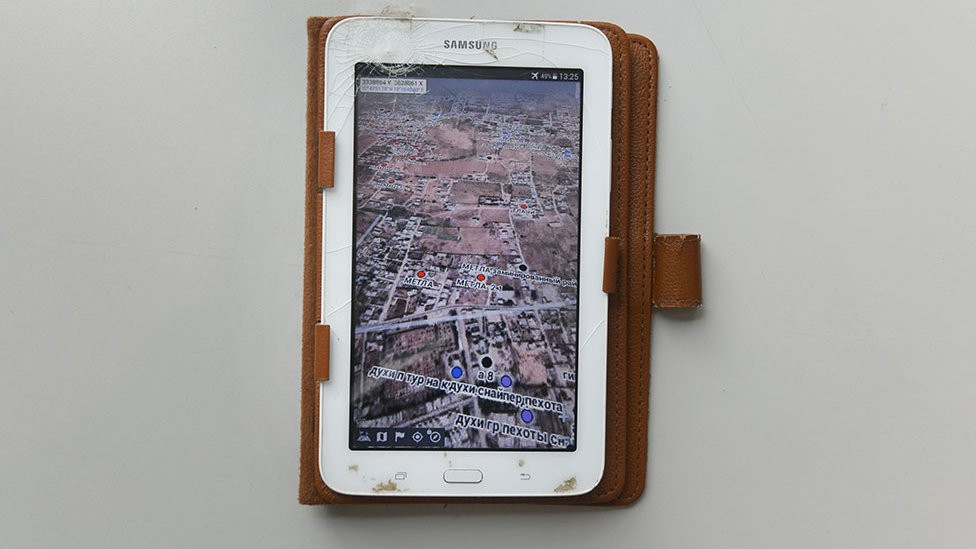 On the tablet's map app are red dots and the name "Metla"