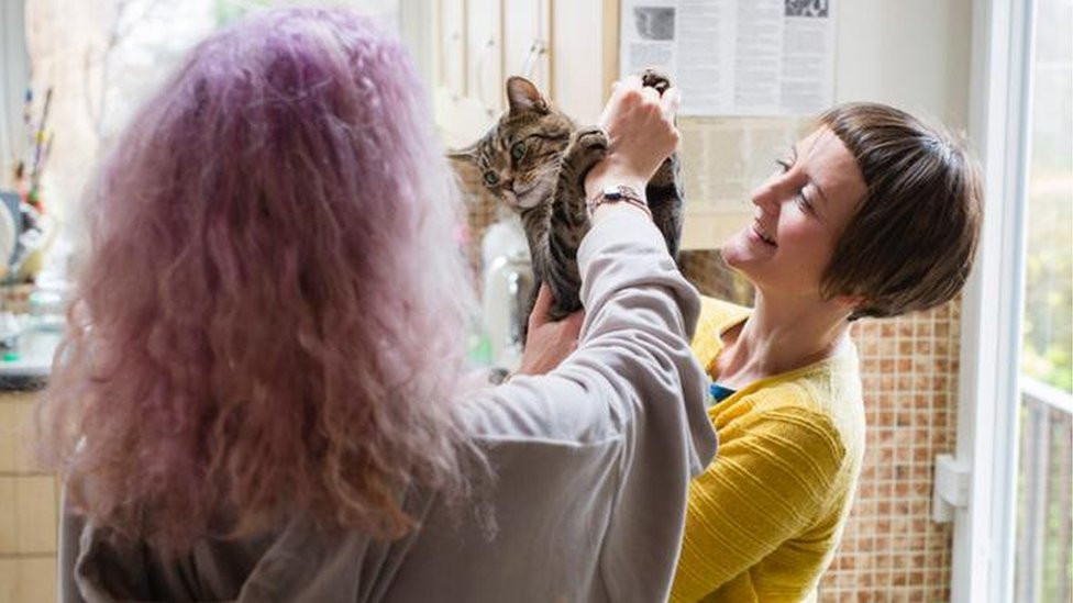 Rachel and her daughter play with a cat