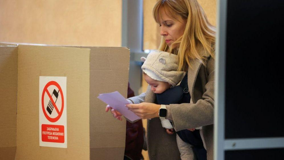 žena glasa sa detetom na izborima 25. oktobra 2025. u Srbiji