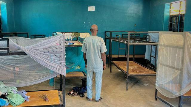 Čovek stoji leđima okrenut kameri u spavaonici sa krevetima u internatu Svete Marije u selu Papiri u državi Niger