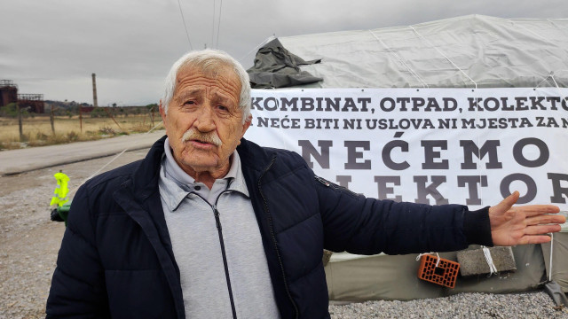 Sedi čovek s brkovima ispred šatora i protestne parole da neće kolektor/