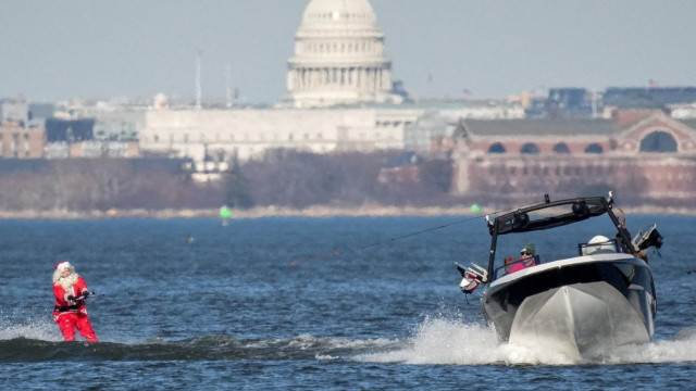 
                    Čovek u kostimu Deda Mraza skija na vodi tokom godišnjeg Festivala skijanja na vodi u gradu Aleksandrija u američkoj saveznoj državi Virdžinija, Božić, merry christmas
  