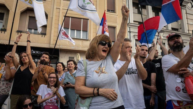 Žena sa podignutom pesnicom u masi na mitingu