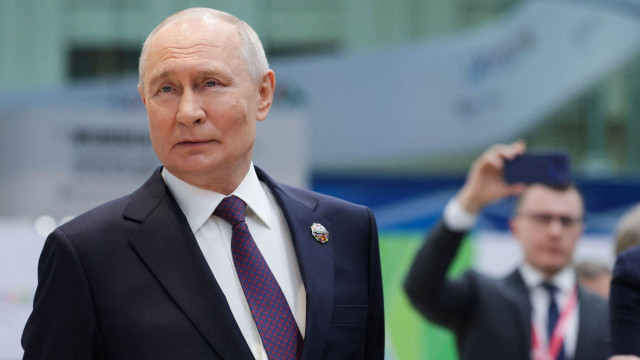 Vladimir Putin u tamonom odelu, beloj košulji i ljubičastoj kravati